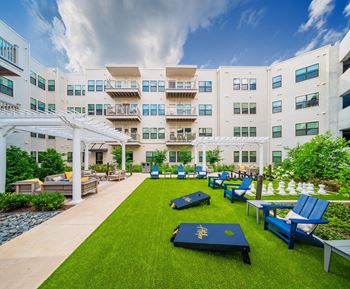 A white building with blue chairs and tables in front.
