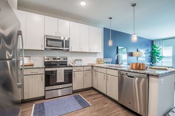 A modern kitchen with stainless steel appliances and wooden cabinets.