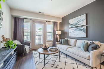 A living room with a couch, coffee table, and a large window.