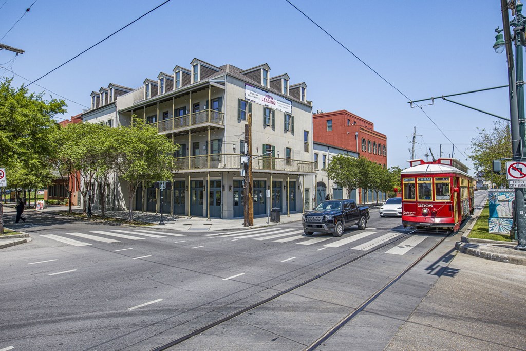 A street view with a red tram on the right and a building with a sign that says "The".