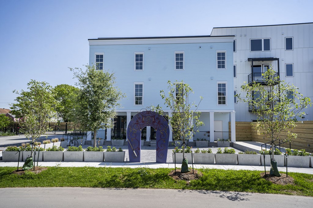 A white building with a purple arch in front of it.