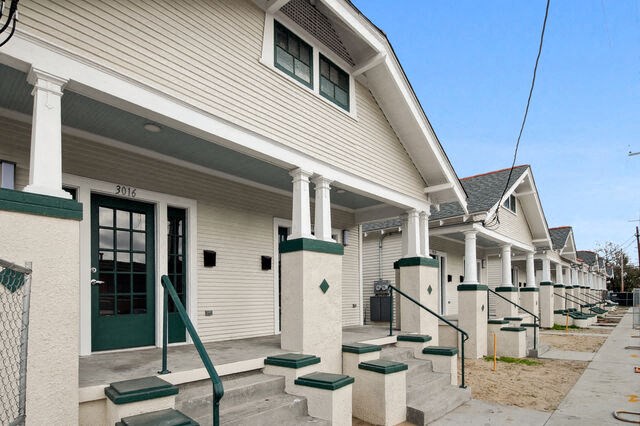 a row of white houses with steps and green railings