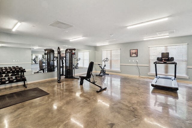 the gym has plenty of exercise equipment and a large window