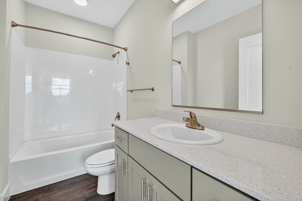 A white bathroom with a toilet, sink, and tub.