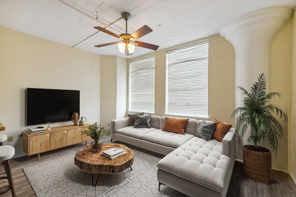 a living room with a couch and a ceiling fan