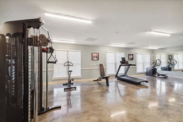 the gym has plenty of exercise equipment and a large window