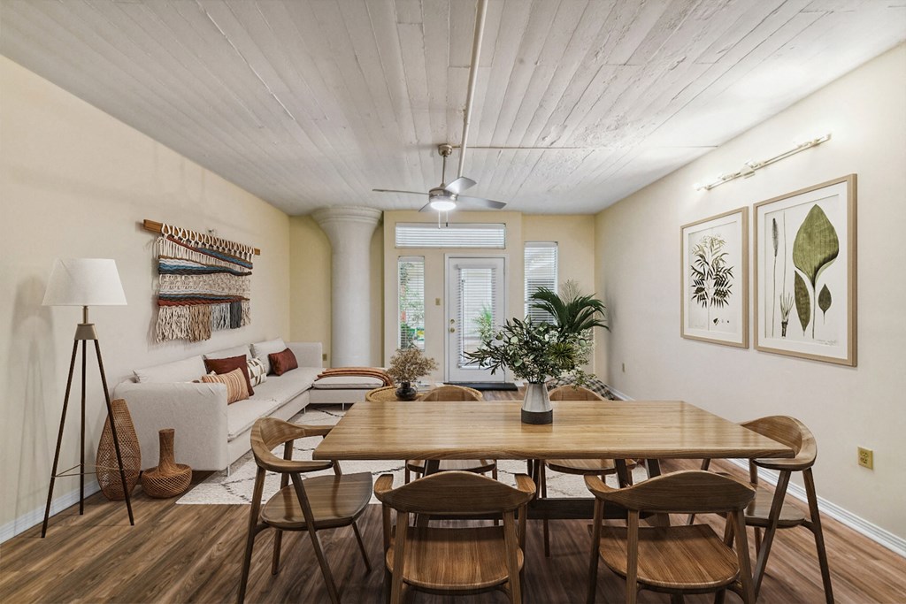 a living room and dining room with a wooden table and chairs