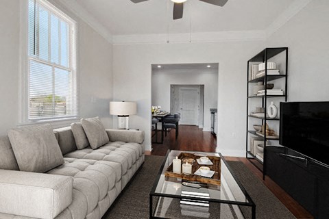 A living room with a white couch and a glass coffee table.