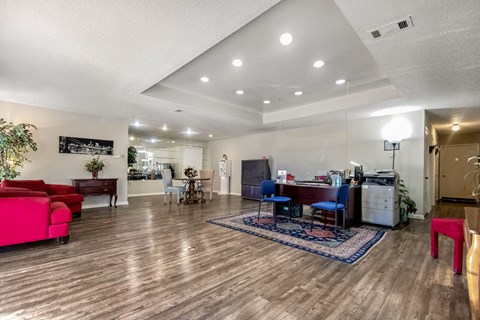 A living room with a red couch and a blue chair.
