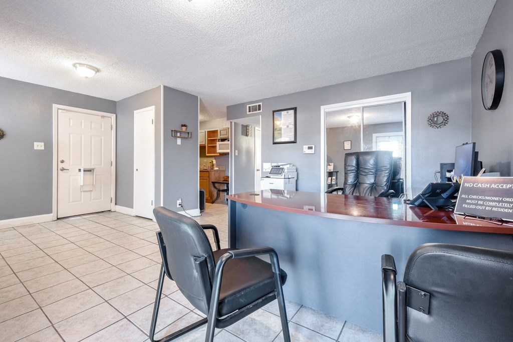 A room with a desk and two chairs.