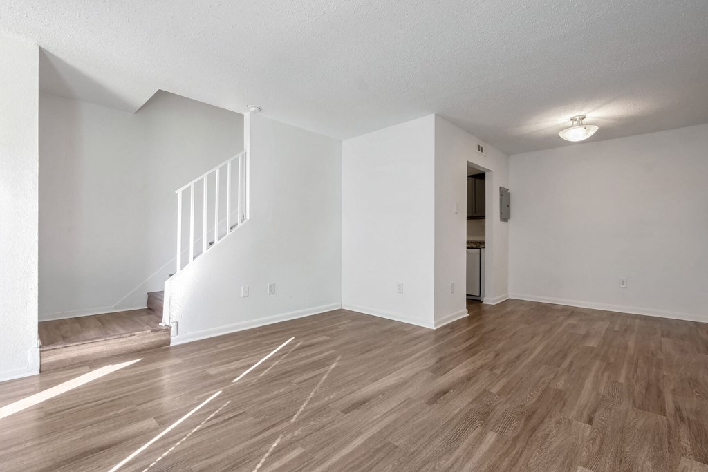 A room with wooden floors and a staircase.