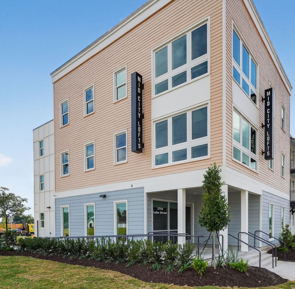 A building with a sign that says "Mid City Lofts".