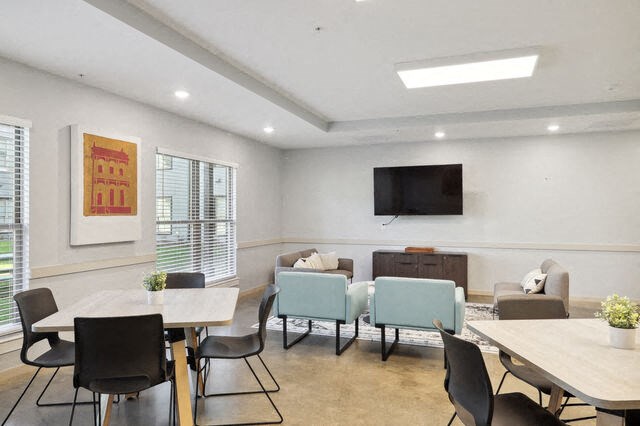 a conference room with tables and chairs and a television