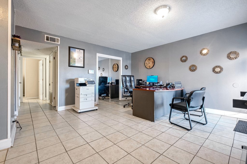 A room with a white tile floor and a brown table with a chair.