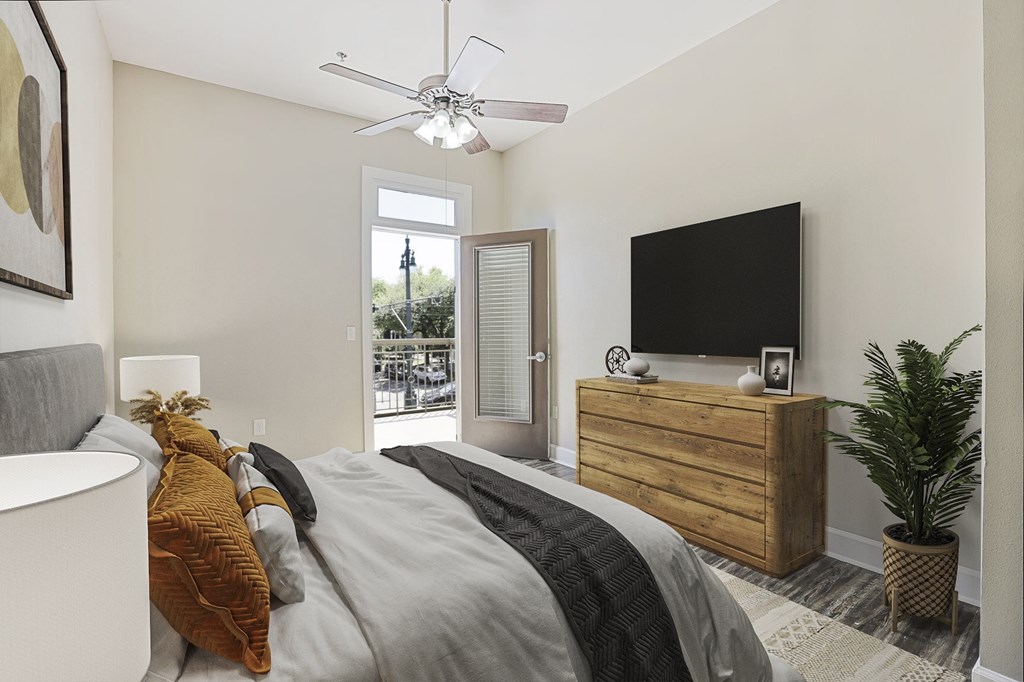 A bedroom with a bed, dresser, and a television.