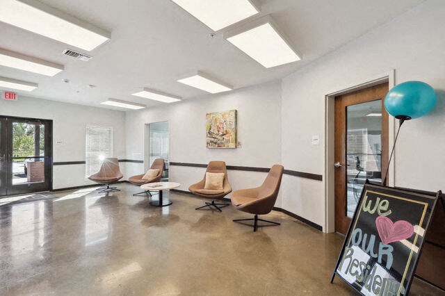 a room with four chairs and a chalkboard in front of a door