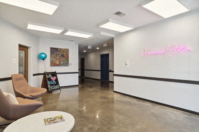 a room with chairs and a table and a hallway with a door