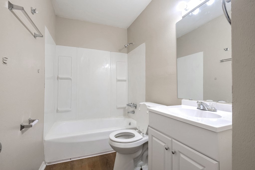 A white bathroom with a toilet, sink, and bathtub.