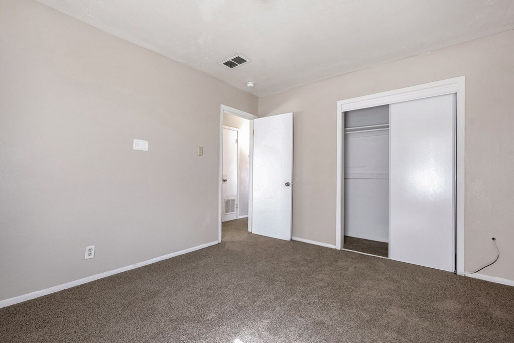 A room with a carpeted floor and a white door.
