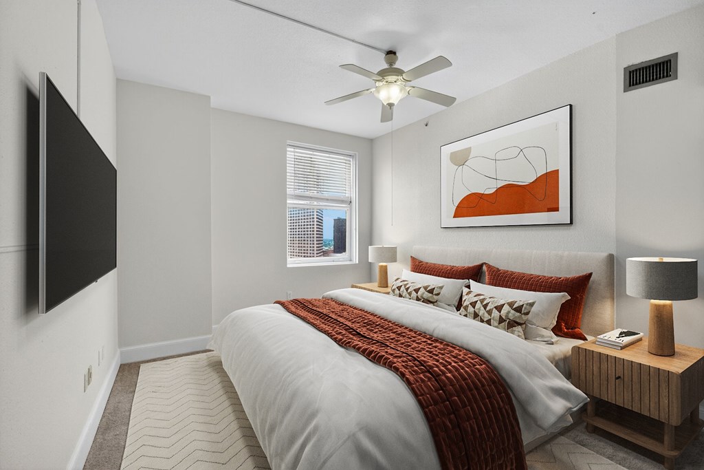 A bedroom with a large bed and a flat screen TV mounted on the wall.