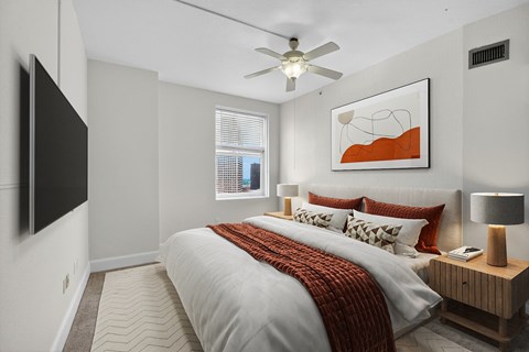 A bedroom with a large bed and a flat screen TV mounted on the wall.