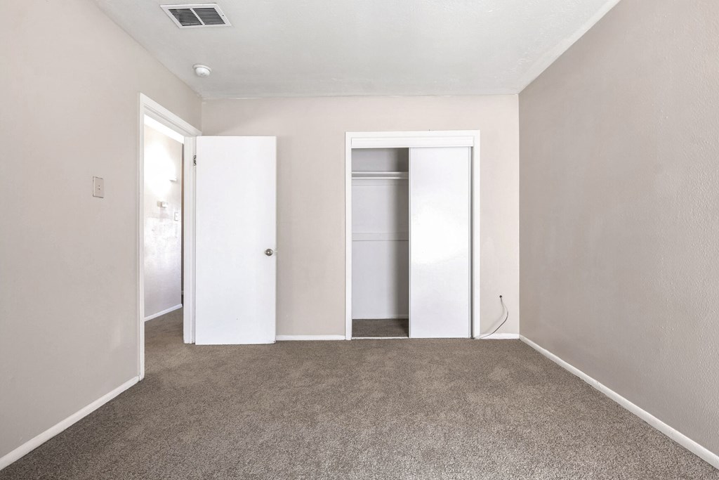 A room with two white doors and a carpeted floor.