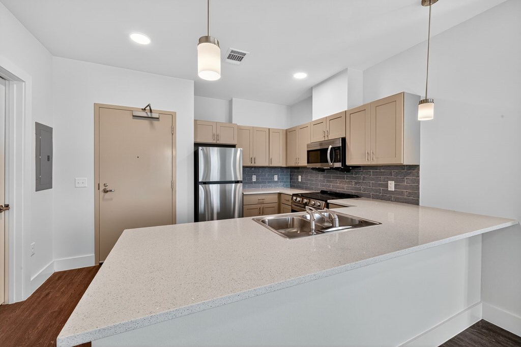 A kitchen with a white countertop and a stainless steel refrigerator.