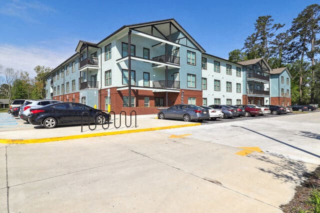 a parking lot with cars in front of an apartment building