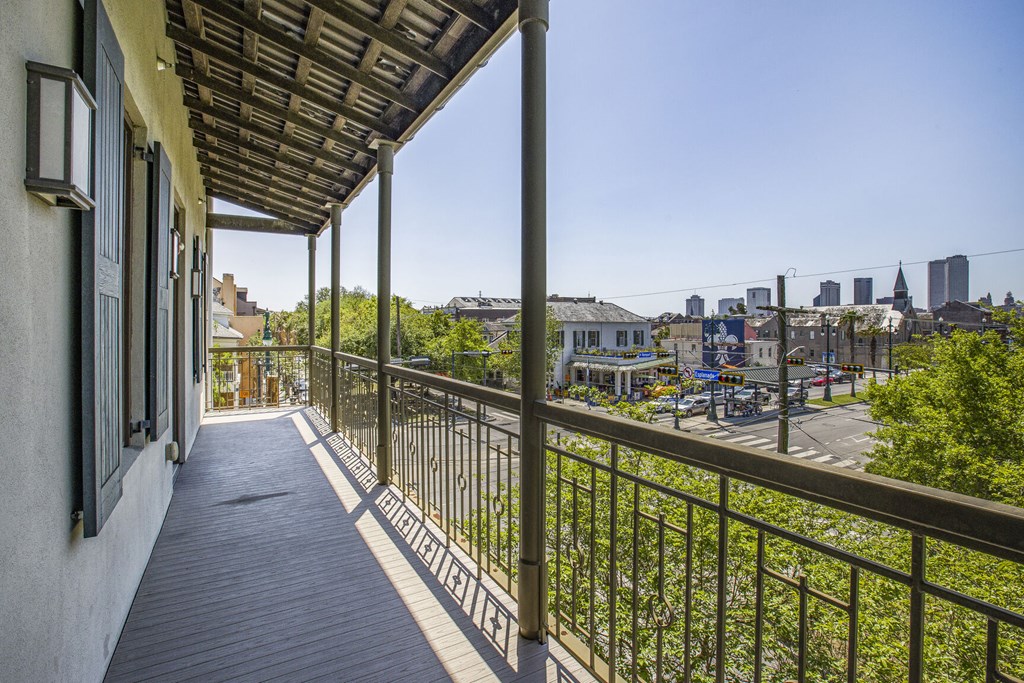 A balcony with a metal railing and a view of a city skyline.