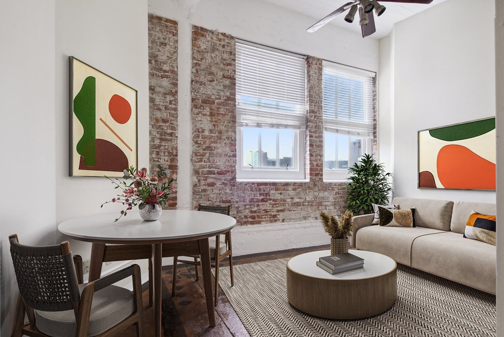 a living room with a round table and a couch and a window