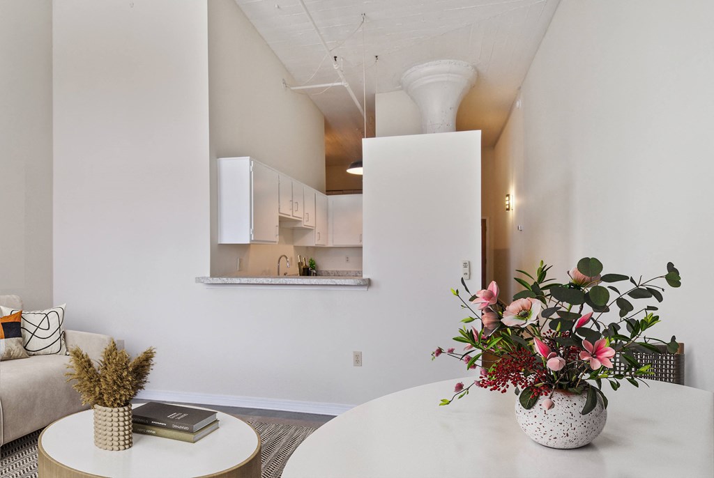 a living room with a table and a vase with flowers
