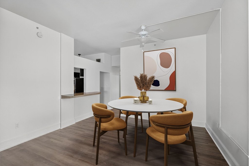 A white dining room with a round table and chairs.