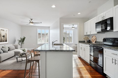 A modern kitchen with a large island and a dining table.