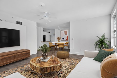 A living room with a white couch and a wooden coffee table.