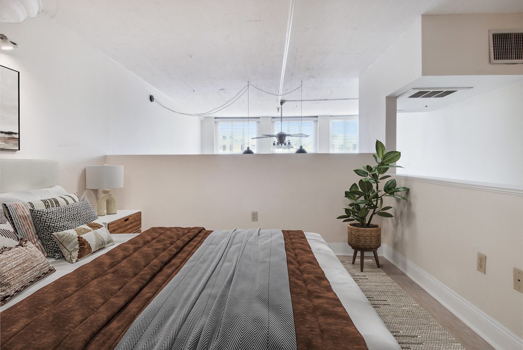 a bedroom with a bed and a potted plant