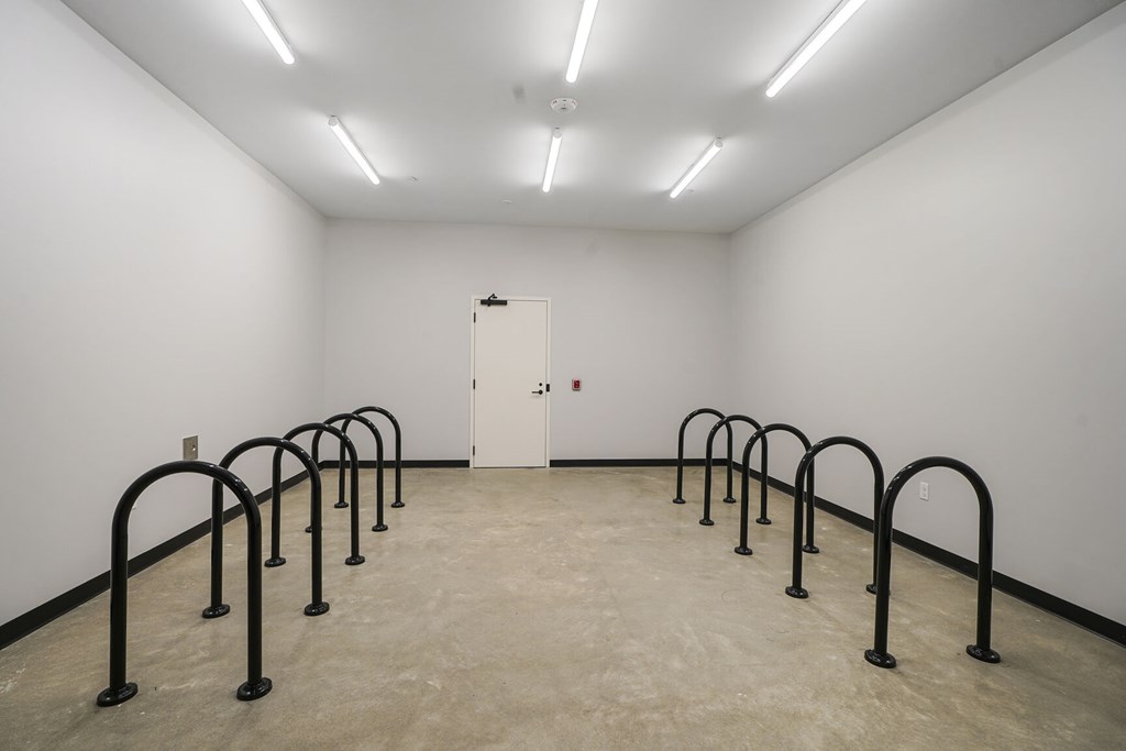 A white room with a white door and black bars on the floor.