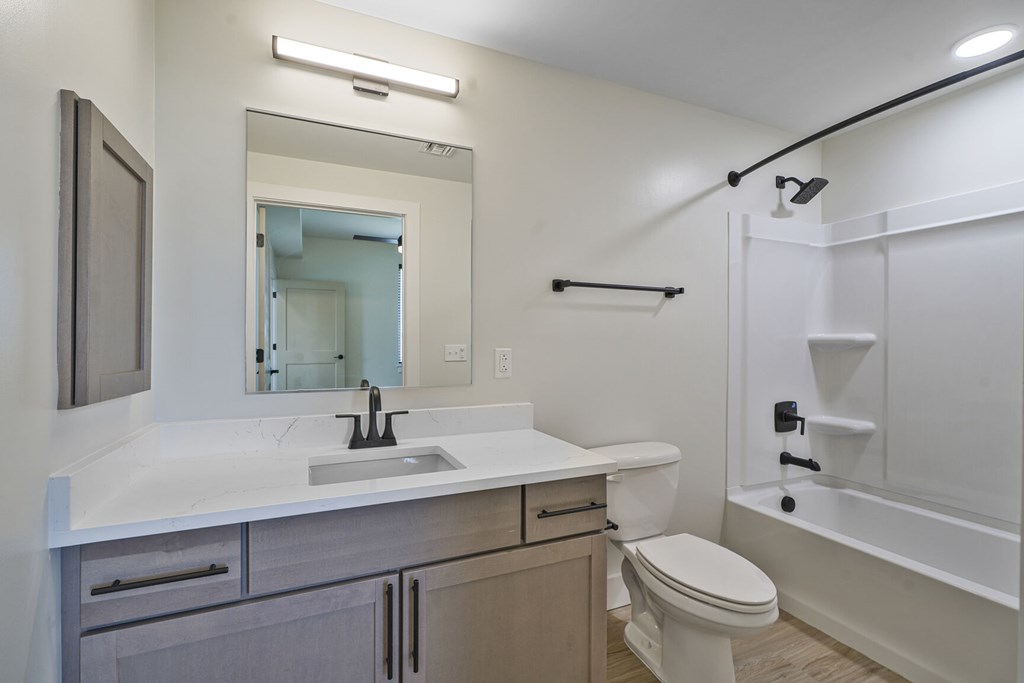 A white bathroom with a sink, toilet, and bathtub.
