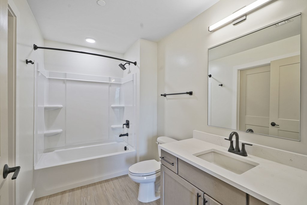 A white bathroom with a toilet, sink, and bathtub.