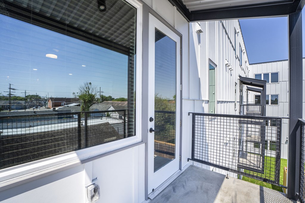 A balcony with a view of a pool and a building.
