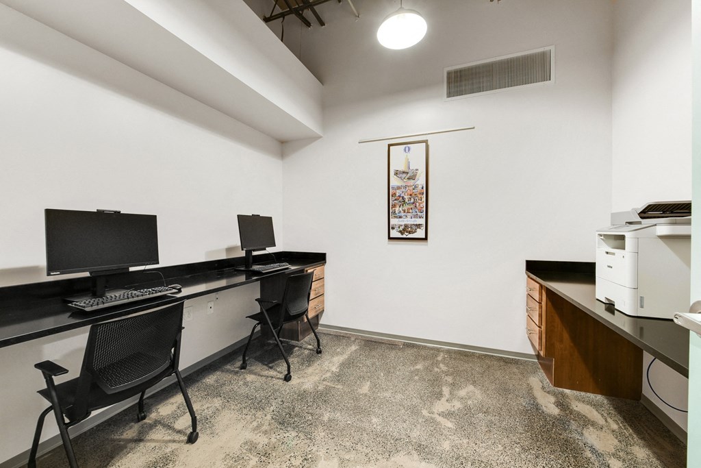 an office space with two desks and a computer