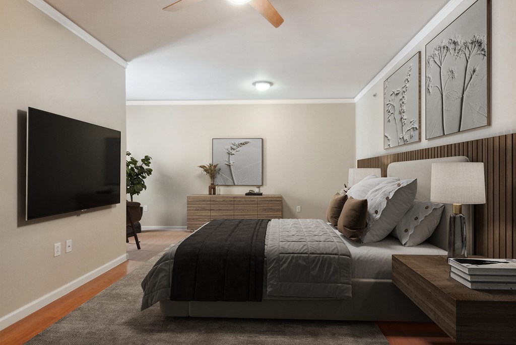 the master bedroom has a large bed and a tv