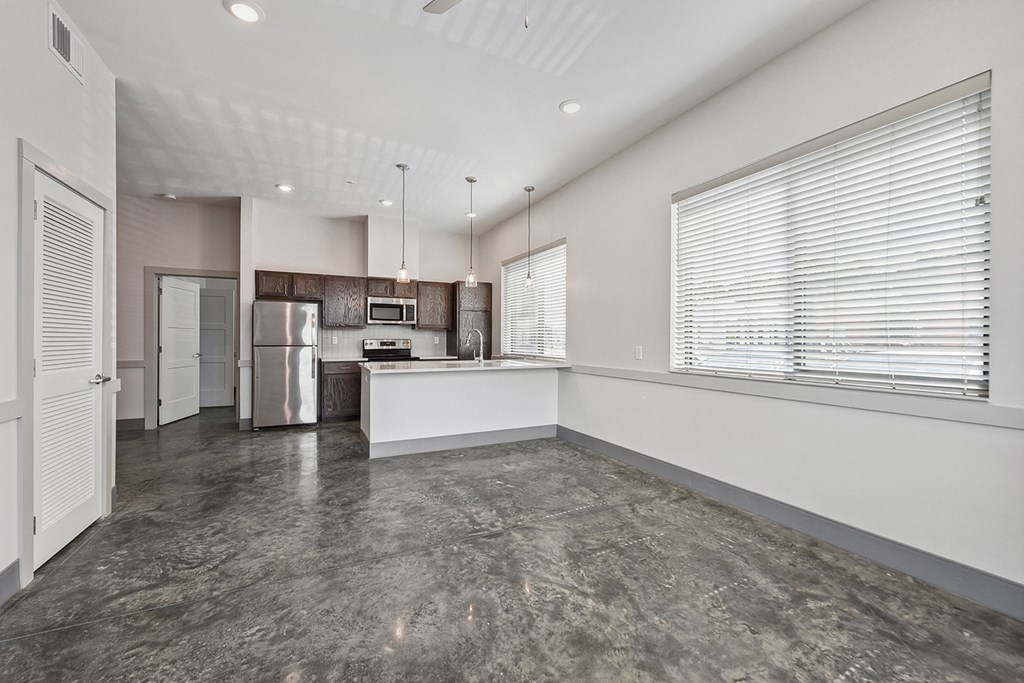 an empty kitchen and living room with a large window