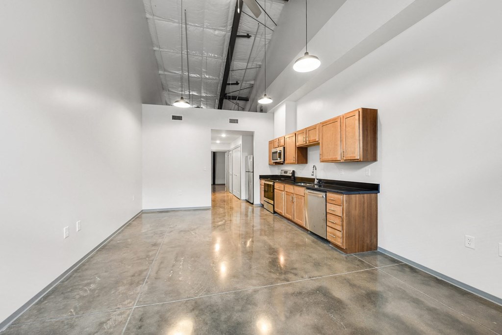 an empty kitchen with wood cabinets and stainless steel appliances