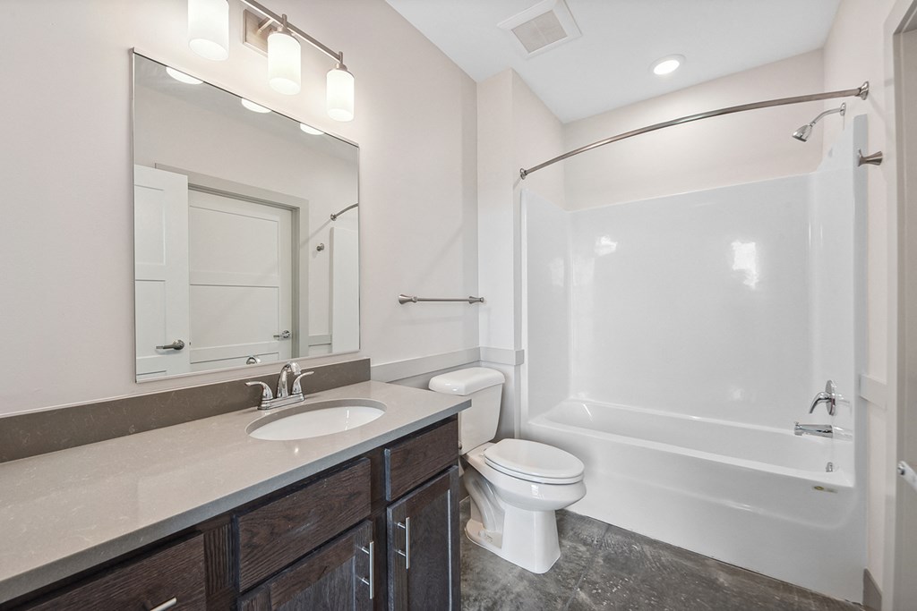 a bathroom with a shower toilet and sink and a mirror