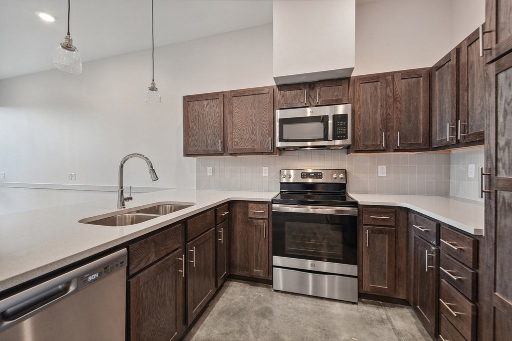 an empty kitchen with wooden cabinets and stainless steel appliances