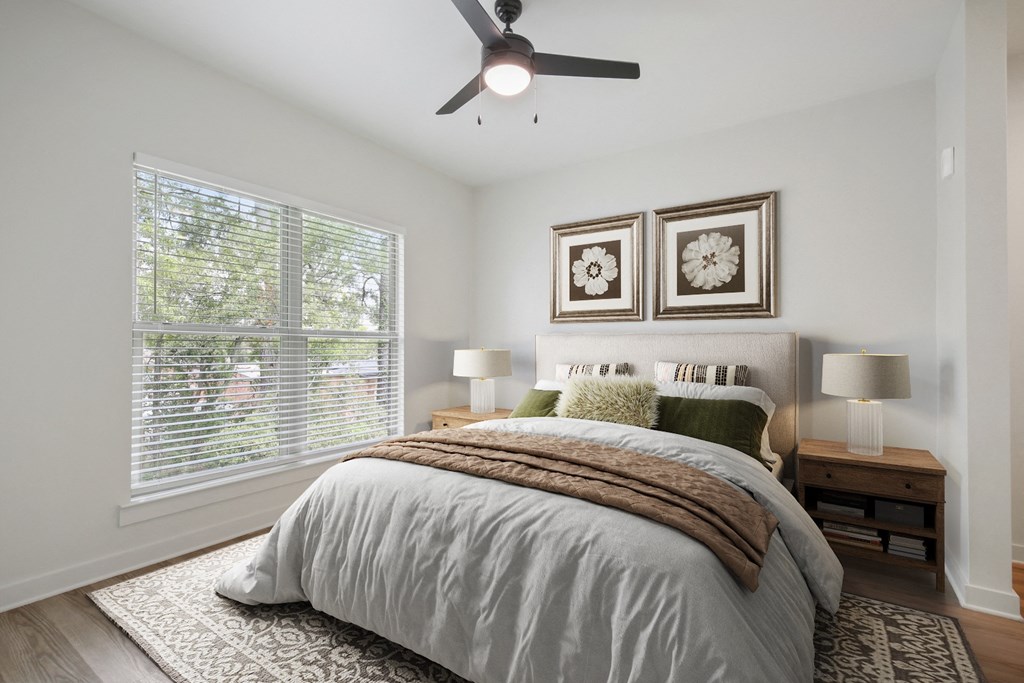 a bedroom with a large bed and a ceiling fan