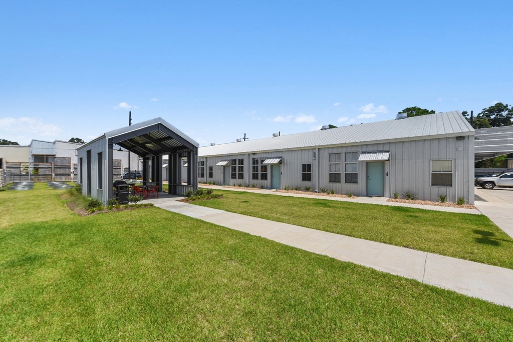 the exterior of a building with a sidewalk and grass