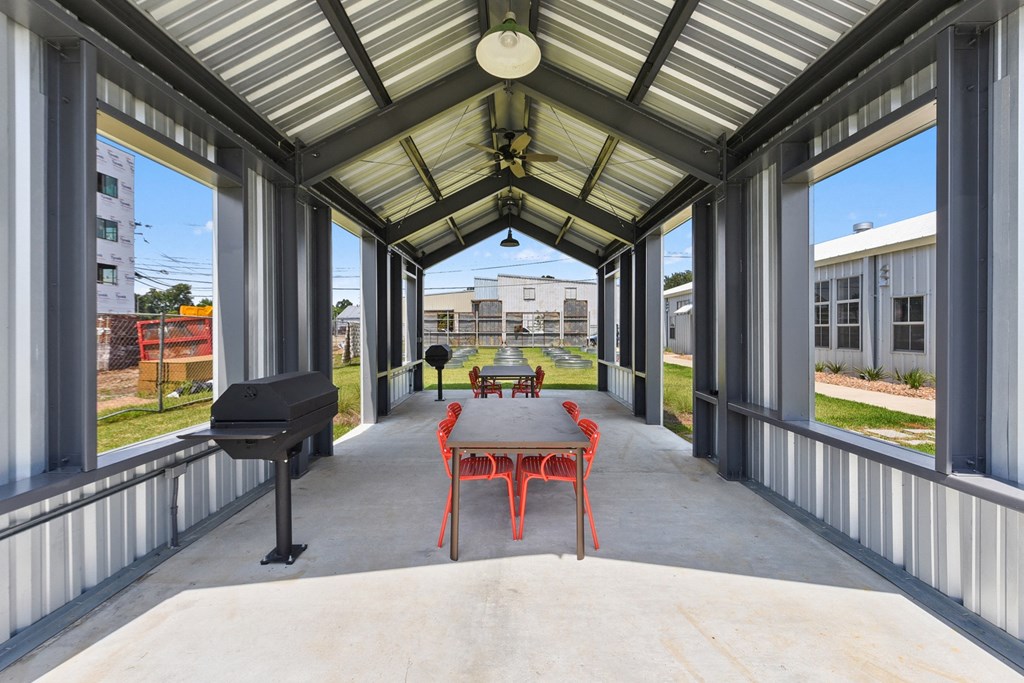 a covered patio with a table and chairs and a piano
