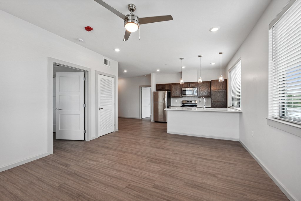 an open living room and kitchen with a ceiling fan