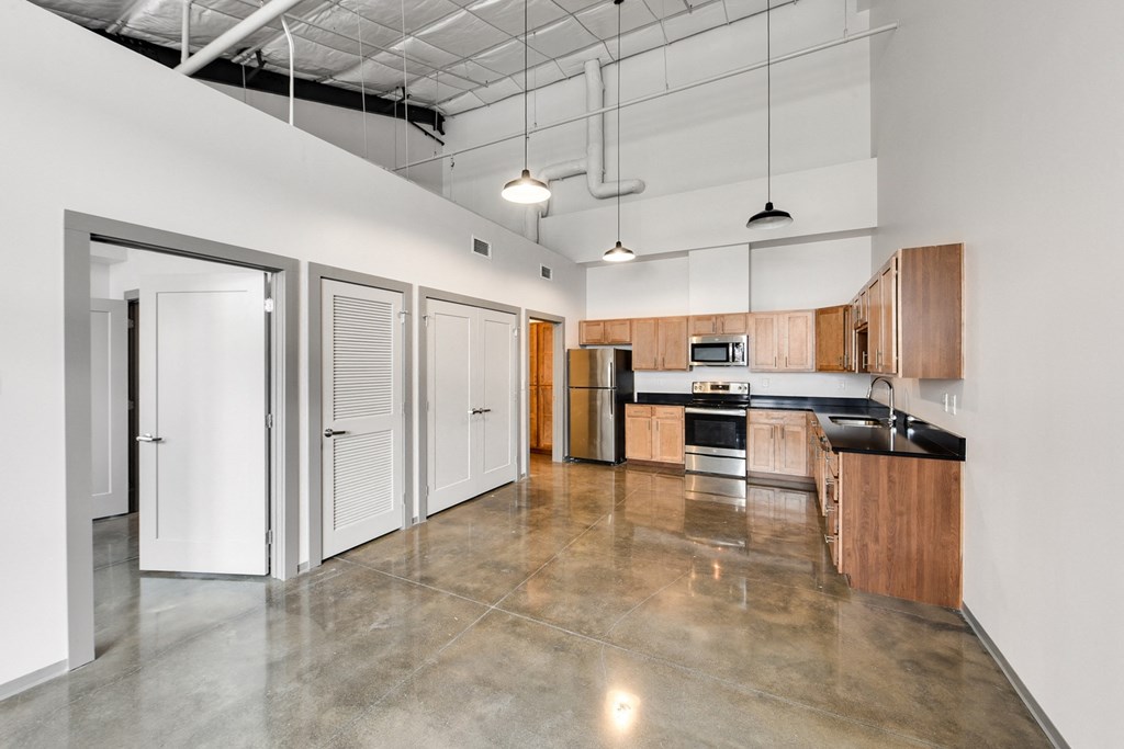 an empty kitchen with white walls and wood cabinets and stainless steel appliances